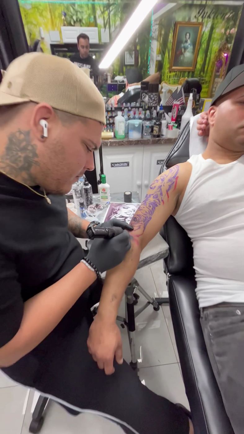 Artista tatuando un brazo